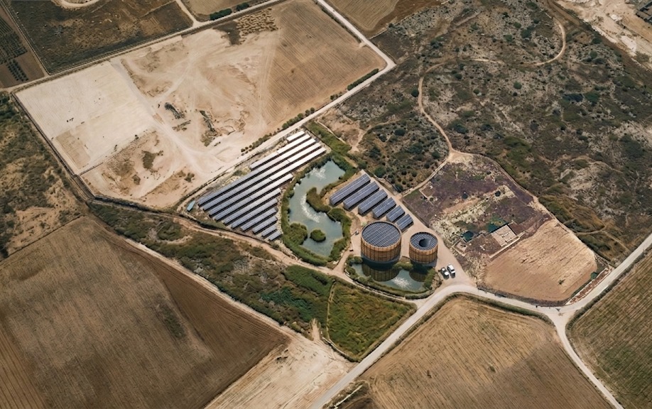 Aerial view of an existing reference site with photovoltaic panels and water reserve
